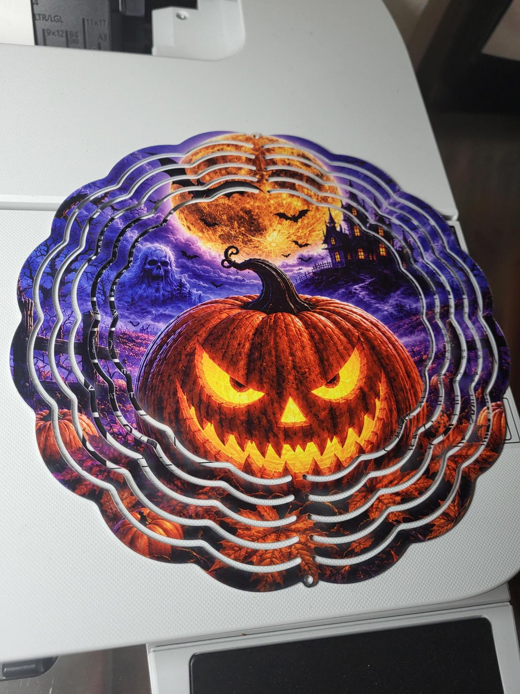 Halloween wind spinner with glowing jack-o-lantern, ghost, haunted mansion and full moon on purple night sky