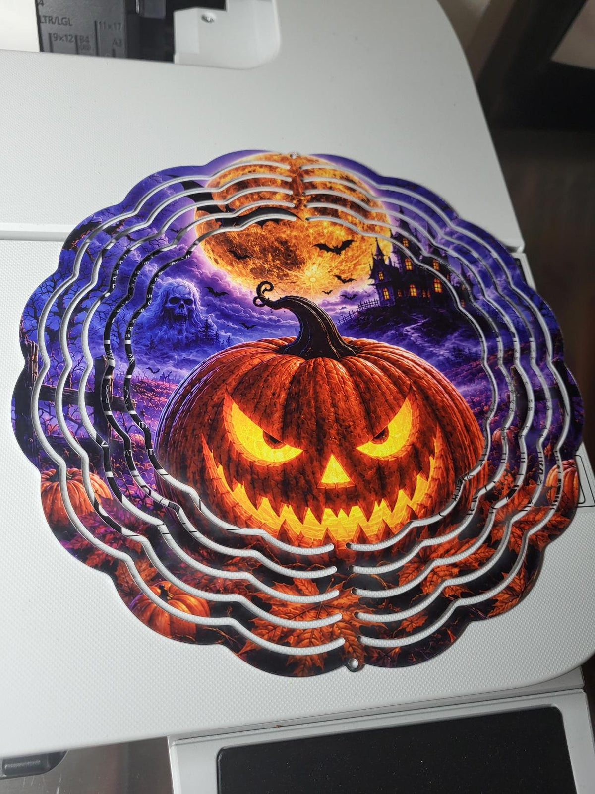 Halloween wind spinner with glowing jack-o-lantern, ghost, haunted mansion and full moon on purple night sky